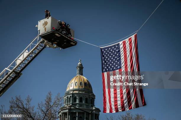 An American Flag is placed over Colfax Avenue during a Funeral Mass for slain Boulder Police officer Eric Talley at The Cathedral Basilica of the...