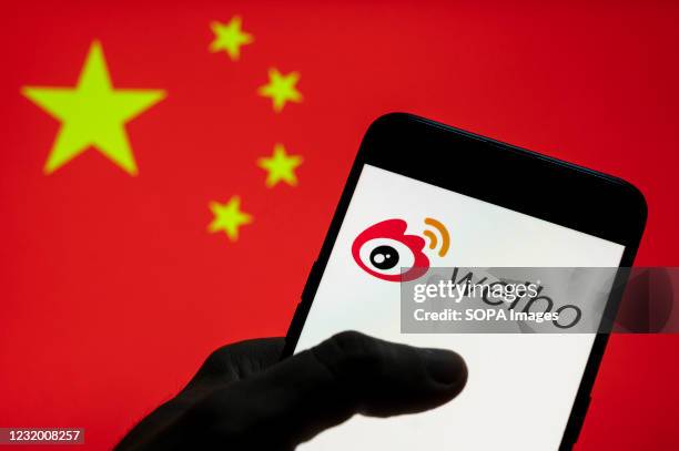 In this photo illustration the Chinese social media platform Weibo logo seen on an Android mobile device with People's Republic of China flag in the...