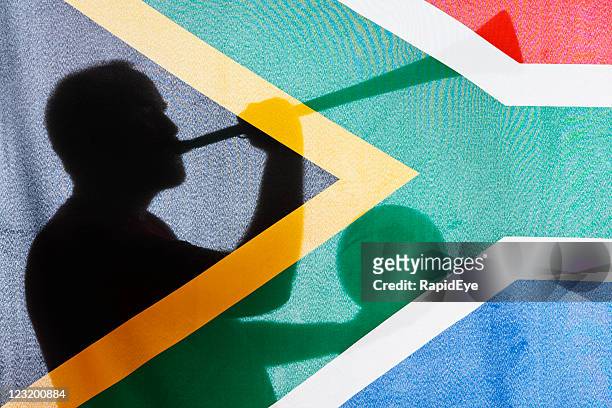 homme de profil, en tenant le ballon et vuvuzela, vu à travers sa drapeau - culture sud africaine photos et images de collection