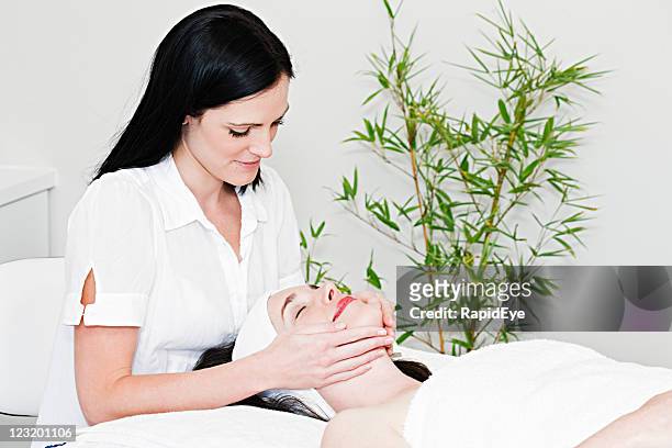 beauty therapist gives face massage - esthetician stock pictures, royalty-free photos & images