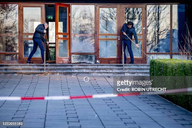 Church workers clean up the damages outside the Mieraskerk , following a small explosion, on March 30, 2021. - Dutch police said a small explosion on...