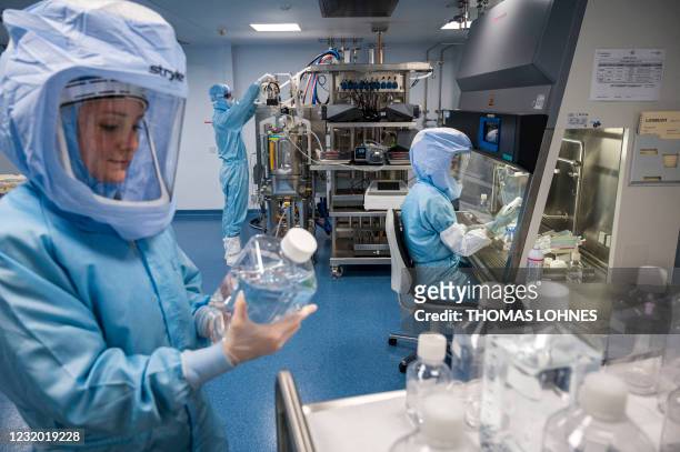 Employees in cleanroom suits test the procedures for the manufacturing of the messenger RNA for the Covid-19 vaccine at the new manufacturing site of...