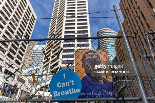 Poster with George Floyd's picture and a sign reads that "I can't Breathe" hang from a security fence outside the Hennepin County Government Center...