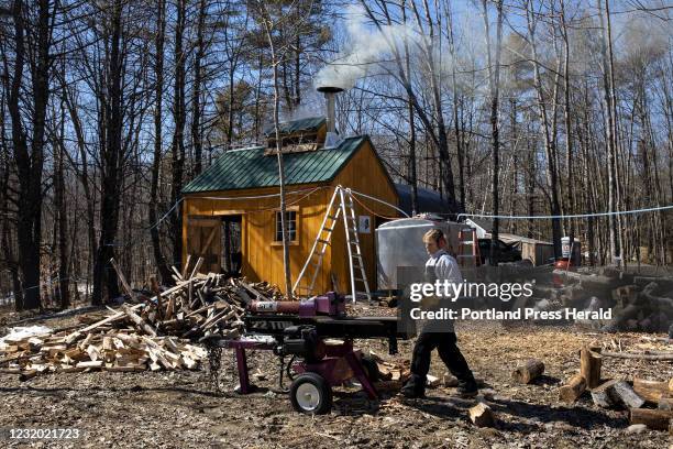 Patti Robinson chops wood for their sugar shack wood stove while her husband, Eric Robinson, boils inside on Wednesday, March 17, 2021. The couple...