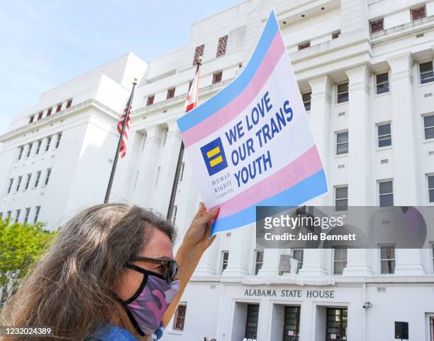 Jodi Womack holds a sign that reads "We Love Our Trans Youth" during a rally at the Alabama State House to draw attention to anti-transgender...