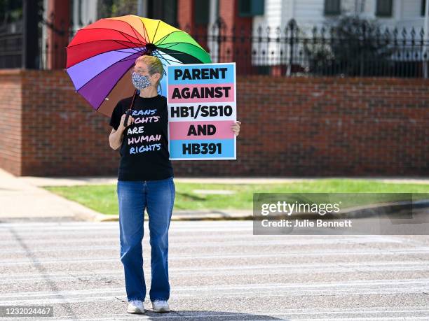 Jan Newton crosses the street to attend a rally at the Alabama State House to draw attention to anti-transgender legislation introduced in Alabama on...