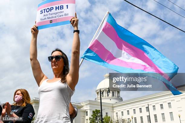 Sydney Duncan holds a sign during a rally at the Alabama State House to draw attention to anti-transgender legislation introduced in Alabama on March...
