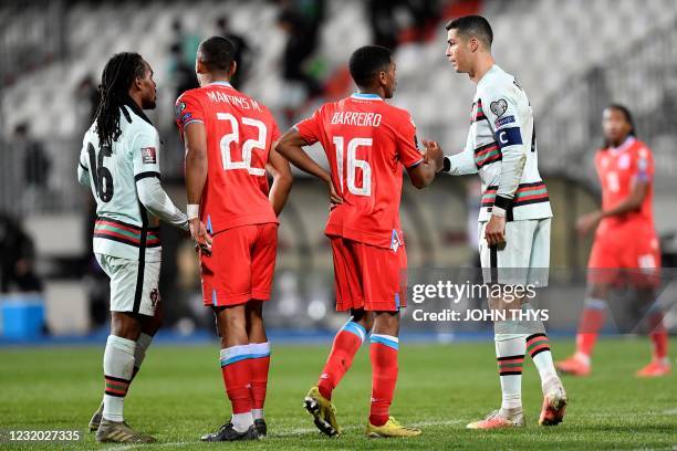 Portugal's midfielder Renato Sanches and Portugal's forward Cristiano Ronaldo shake hands with Luxembourg's defender Marvin Martins and Luxembourg's...