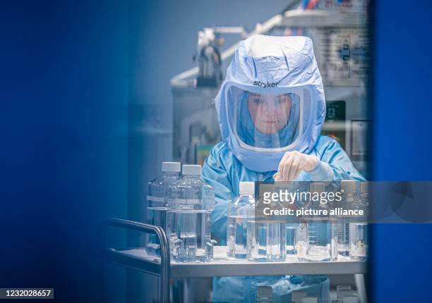March 2021, Hessen, Marburg: Wearing full-body protective suits, laboratory assistants from the company Biontech simulate the final steps in the...