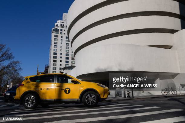 Yellow taxi cab drives past The Solomon R. Guggenheim Museum on March 30, 2021 in New York City.