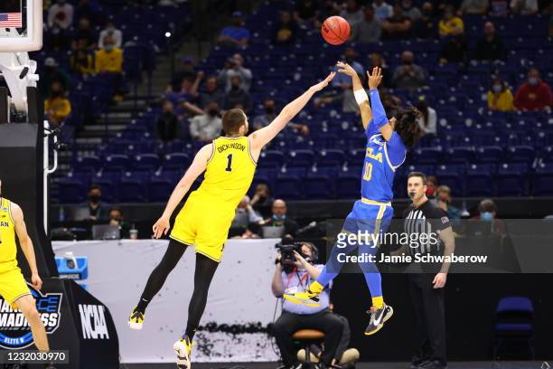Tyger Campbell of the UCLA Bruins shoots a jumper over Hunter Dickinson of the Michigan Wolverines in the Elite Eight round of the 2021 NCAA Division...