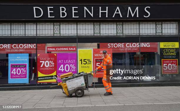 Signs in the window of a closing Debenhams store offer sales bargains on the High Street in Winchester, south west England on March 31, 2021.