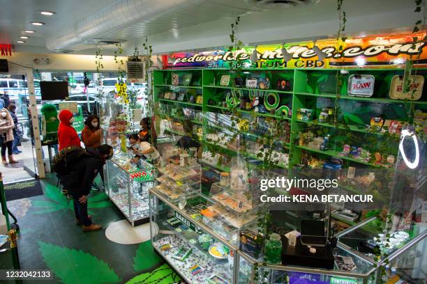 People visit the Weed World store on March 31 in Midtown New York. - New York Governor Andrew Cuomo signed legislation legalizing recreational...