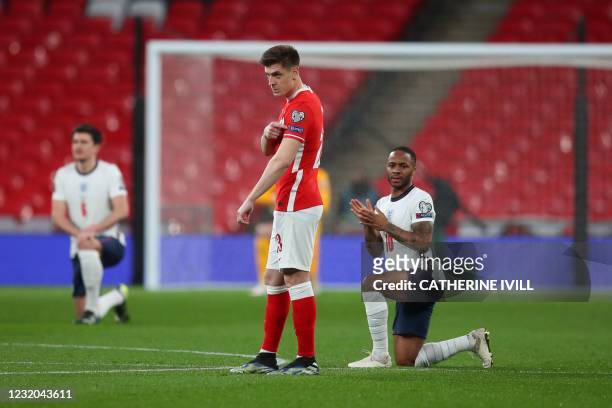 England's midfielder Raheem Sterling and the England players take a knee against racism as Poland's forward Krzysztof Piatek points to his 'respect'...