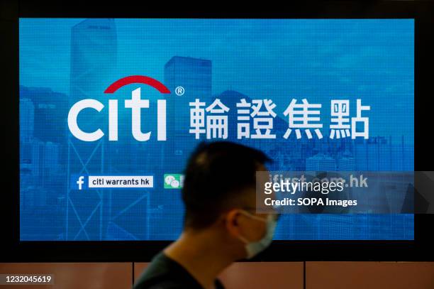 Commuter walks past a screen commercial ad of the American multinational investment bank, Citibank or Citi, at MTR subway station in Hong Kong.