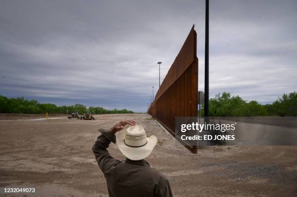 In a photo taken on March 28, 2021 ranch owner Tony Sandoval stands before a portion of the unfinished border wall that former US president Donald...