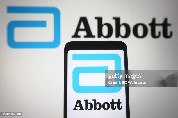 In this photo illustration, the Abbott Laboratories logo of the US medical device company seen displayed on a smartphone and a pc screen.