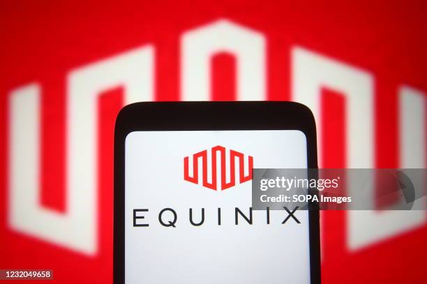In this photo illustration, an Equinix logo of the US real estate investment trust company seen displayed on a smartphone and a pc screen.