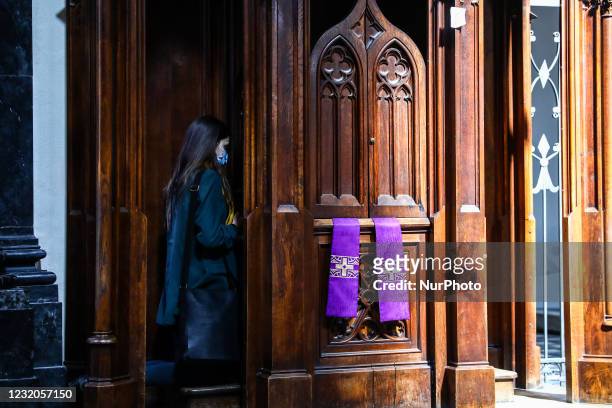 Woman attends confession inside the The Basilica of Holy Trinity during the coronavirus pandemic in Krakow, Poland on April 1, 2021.
