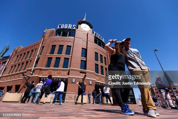 Fans pose outside the stadium ahead of a game between the Los Angeles Dodgers and Colorado Rockies on Opening Day at Coors Field on April 1, 2021 in...
