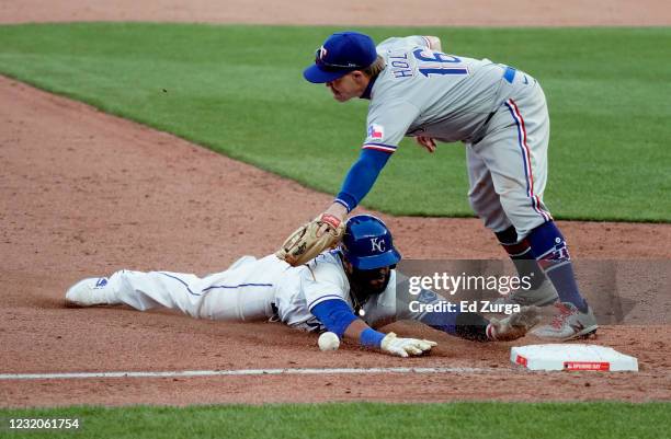 Carlos Santana of the Kansas City Royals slides safely into third base against Brock Holt of the Texas Rangers on a double off the bat of Jorge Soler...