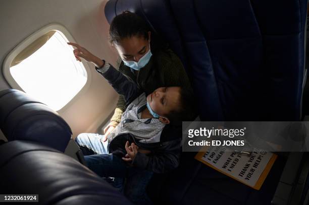 Central American migrants Lidia and her son Isaac sit aboard their flight on March 30, 2021 from McAllen to Houston after being released from a US...