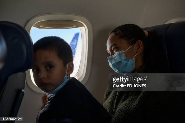Central American migrants Lidia and Isaac sit aboard their flight on March 30, 2021 from McAllen to Houston after being released from a US government...
