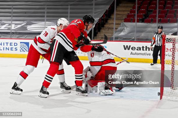 Dylan Strome of the Chicago Blackhawks scores a goal past Steven Lorentz and James Reimer of the Carolina Hurricanes in the third period at the...