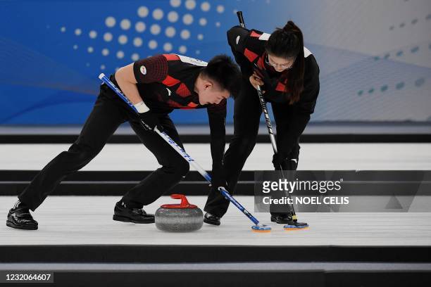 Chinese players take part in a curling test event for the 2022 Beijing Winter Olympic Games at the National Aquatics Center, known as the Ice Cube,...