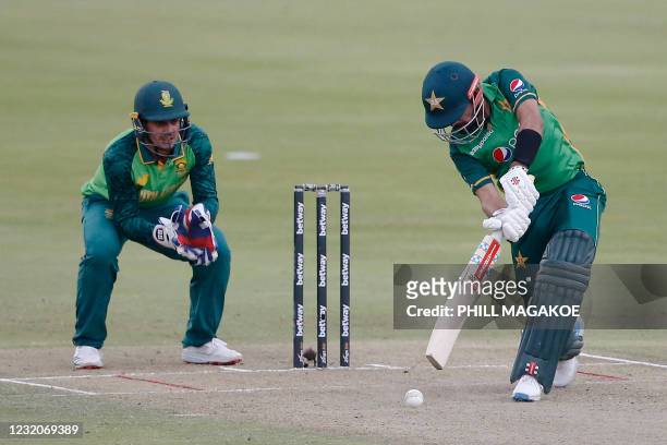 Pakistan's captain Babar Azam plays a shot as South African wicketkeeper Quinton de Kock looks on during the first one-day international cricket...