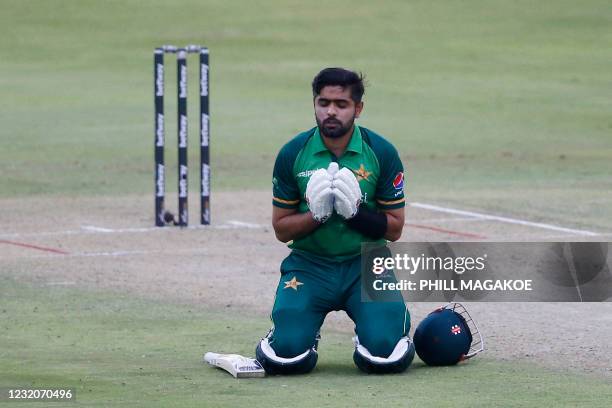 Pakistan's captain Babar Azam kneels down while celebrating after scoring a century during the first one-day international cricket match between...