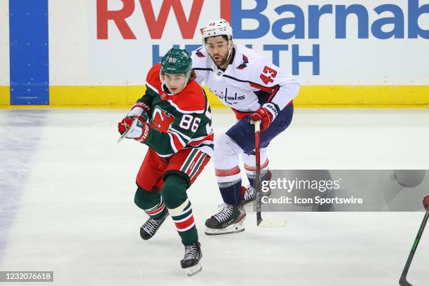 New Jersey Devils center Jack Hughes and Washington Capitals right wing Tom Wilson skate during the first period of the National Hockey League game...