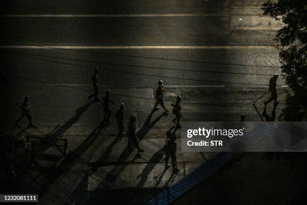 This picture taken on April 2, 2021 shows soldiers patrolling along a street in Yangon, as the country remains in turmoil with security forces...