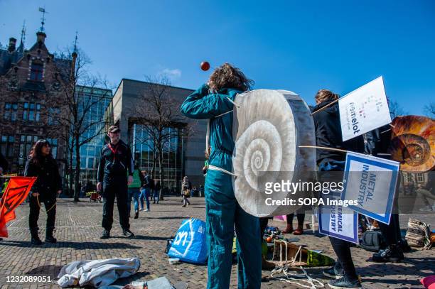 An XR activist dressed like a snail is seen listening to the arbitrator before the race. To symbolize the slow-moving towards net-zero emissions,...
