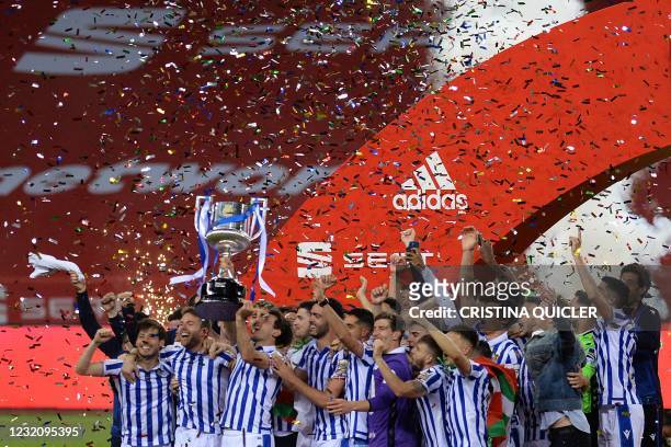 Real Sociedad's players celebrate with the trophy after winning the 2020 Spanish Copa del Rey final football match between Athletic Bilbao and Real...