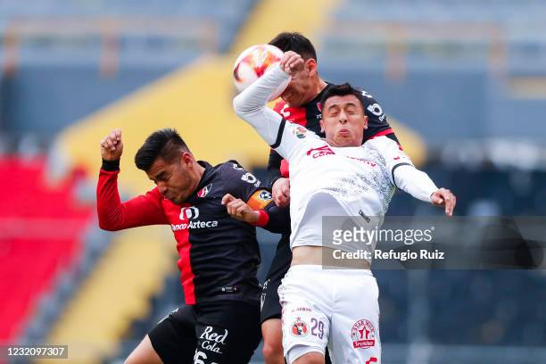 Aldo Rocha of Atlas jumps for the ball with Edgar López of Tijuana during the 13th round match between Atlas and Club Tijuana as part of the Torneo...