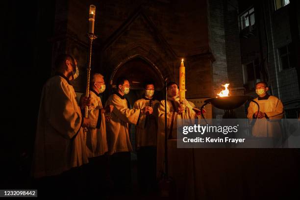 Chinese Catholic clergy light a cauldron as part of the holy fire at an Easter mass at a Catholic church on April 3, 2021 in Beijing, China. With the...