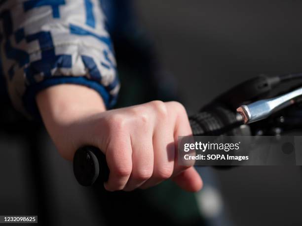 Close up view of a teenagers hand on the bicycle handlebars.