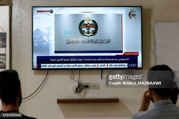 Jordanians follow the latest political developments in their country on a television set at a cafe in the capital Amman, on April 4, 2021. - Jordan's...