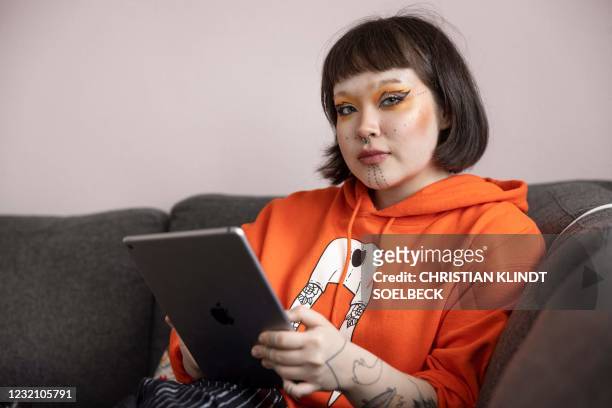 Inuit activist and artist Seqininnguaq Lynge Poulsen poses with her Ipad in her home in Nuuk with her dog Pablo , on March 24 Nuuk, Greenland. - Her...