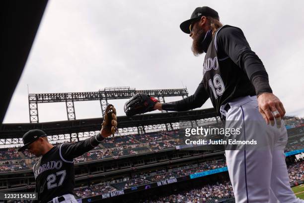 Charlie Blackmon of the Colorado Rockies is congratulated on his outfield assist to end the first inning by Trevor Story during a game against the...