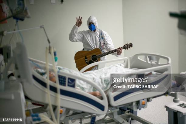 Health worker from the Portuguese charity hospital in Belem, Para State, Brazil, sings and prays for a COVID-19 patient inside the hospital wards and...
