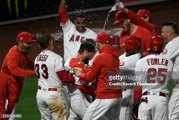 Jared Walsh of the Los Angeles Angels is mobbed by his teammates as he celebrates his game winning three run home run in the ninth inning against...