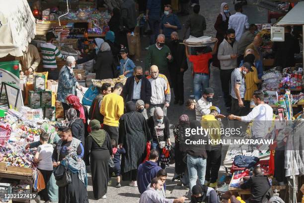 Shoppers look at stalls at a public market in Jordan's capital Amman, on April 5 after a rare security operation took place in the country. -...