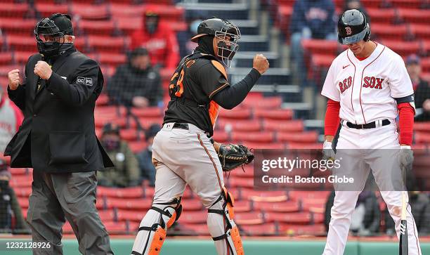 Home plate umpire Joe West signals called strike three, Orioles catcher Pedro Severino pumps his fist and the Red Sox Bobby Dalbec hangs his head as...