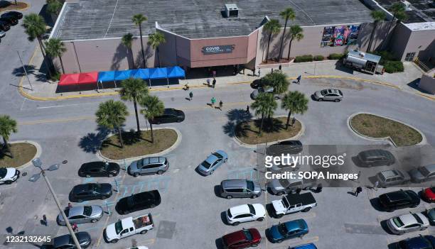 Aerial view of people arriving to receive COVID-19 shots at a vaccination site in a former Sears store at the Lake Square Mall on the first day that...