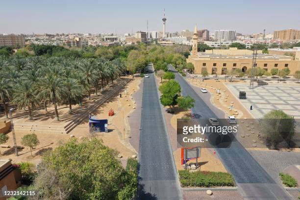 An aerial picture shows cars driving down a road next to a park area in the Saudi capital Riyadh, on March 29, 2021. - Although the OPEC kingpin...
