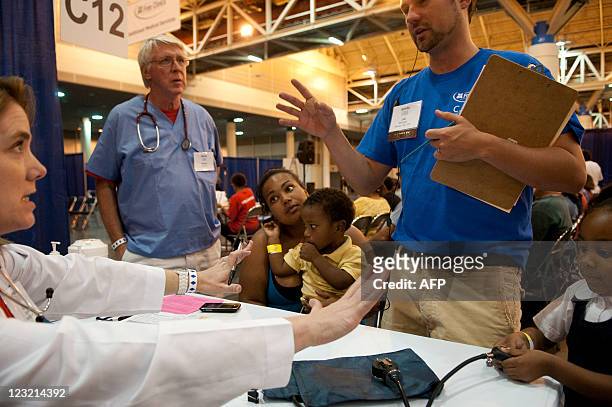 Avanna Parent of New Orleans, LA, sits with her two year-old son Leo and five year-old daughter Paige as they are assisted by Dr. Kim Davis of...