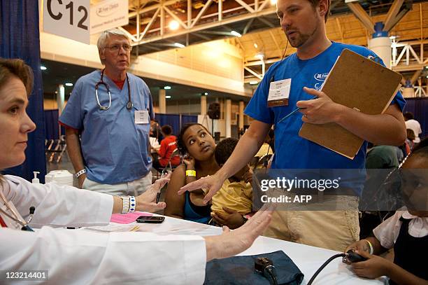 Avanna Parent of New Orleans, LA, sits with her two year-old son Leo and five year-old daughter Paige as they are assisted by Dr. Kim Davis of...