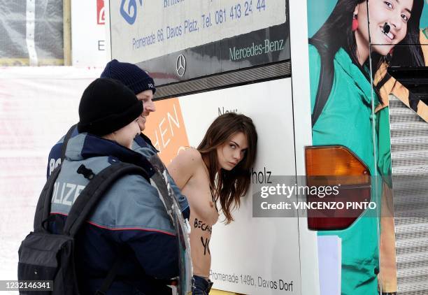 An activist from Ukrainian feminist group " Femen " is arrested by Swiss police as they make a topless protest on January 28 against the World...